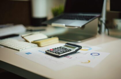 Photo by Jakub Żerdzicki a calculator sitting on top of a table next to a laptop