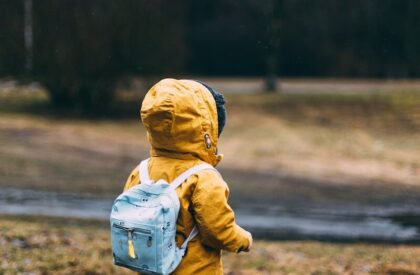 shallow focus photo of toddler walking near river